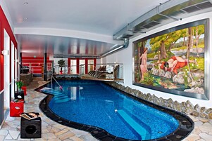 A swimming pool with a stone border, a mural of a natural scene, and a red and white color scheme in the background.