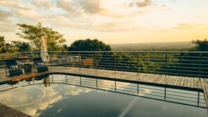 A pool area with a wooden deck, lounge chairs, and a view of the landscape. - Schimper View Boutique Guest House (Louis Trichardt)