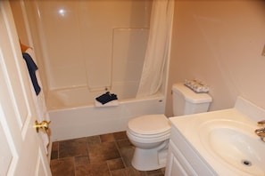 Une salle de bain avec une baignoire, des toilettes et un lavabo.