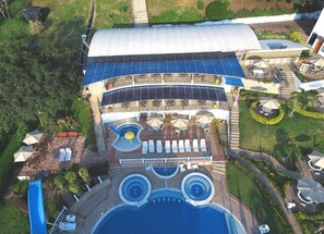 A resort with a pool, sun loungers, umbrellas, and a covered patio area. - Villeta Resort Hotel (Villeta)