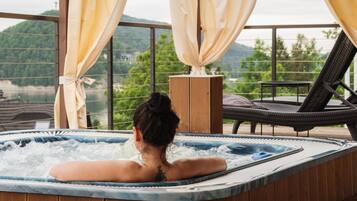 A hot tub with a view of a mountainous landscape.