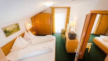 Ein Hotelzimmer mit Bett, Schreibtisch, Stuhl, Fernseher und einem Bild an der Wand.