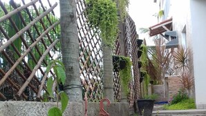 A garden area with potted plants, a bamboo fence, and a concrete wall. - Tribo De Gaia (Conceicao da Barra)
