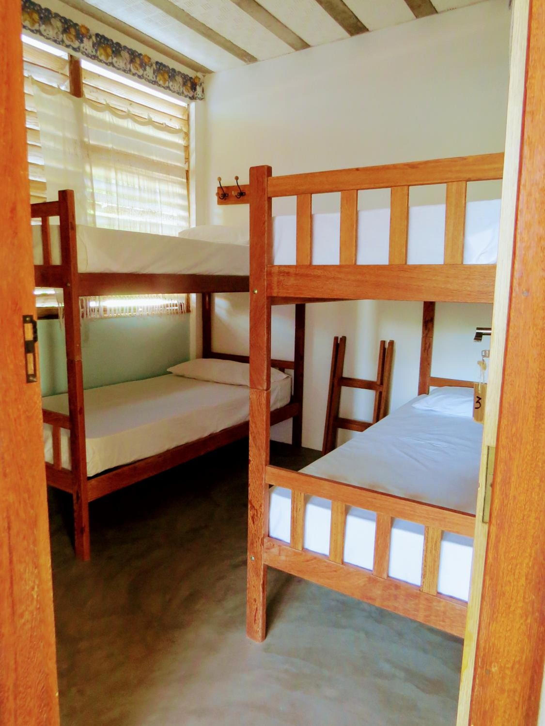 Habitación con literas, ventana y cortinas.