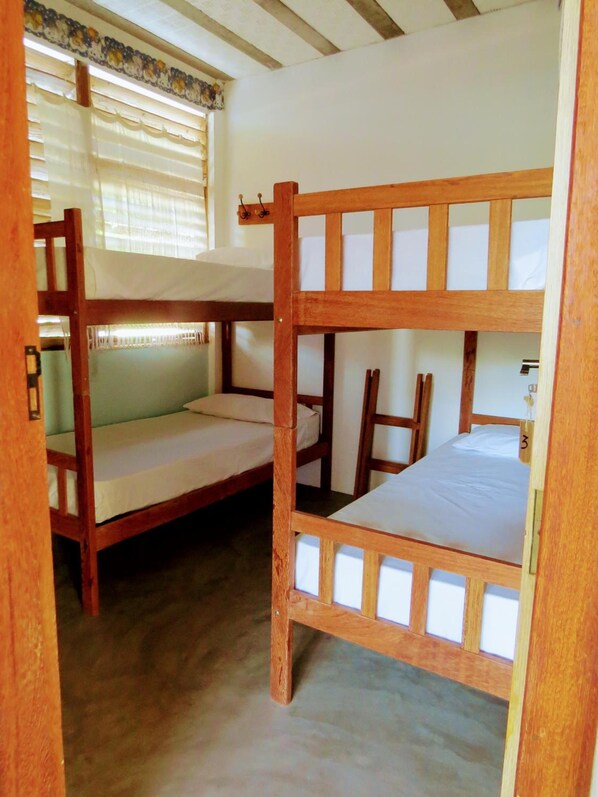 A bunk bed room with a window and curtains.