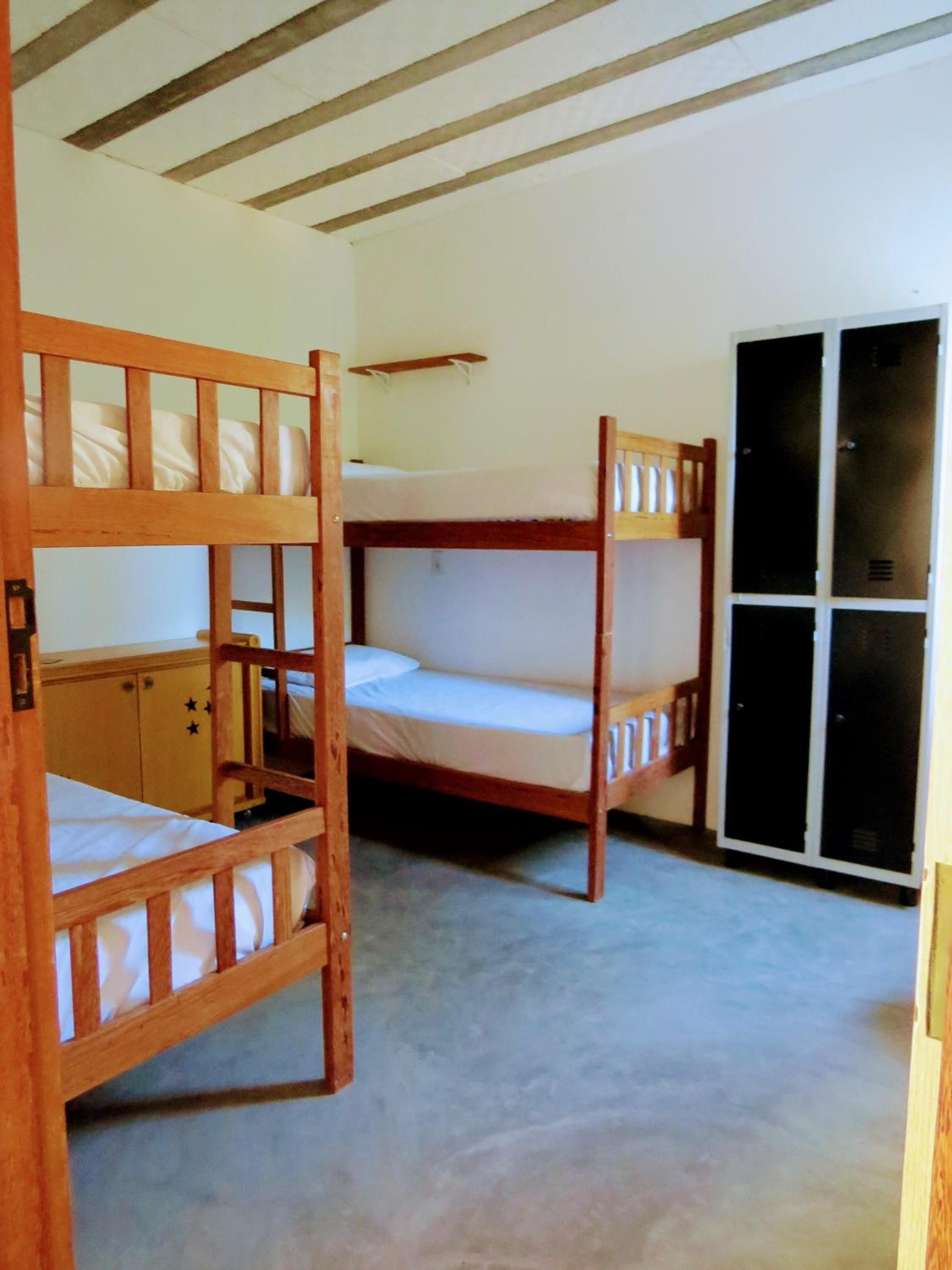 Quarto com beliches, guarda-roupa e porta deslizante.