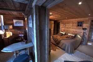 Una habitación rústica de madera con una cama, un escritorio y una silla.