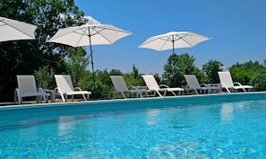 A swimming pool with white lounge chairs and umbrellas. - Sinjirite Complex (Elena)