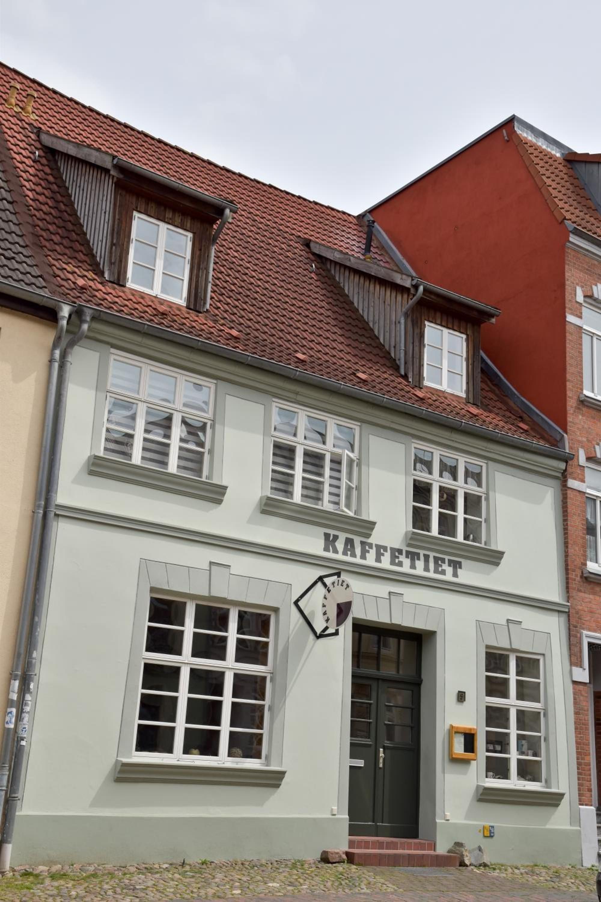 Ein Gebäude mit einem Schild, auf dem 'KAFFETIET' steht, das auf ein Café oder Restaurant hinweist.