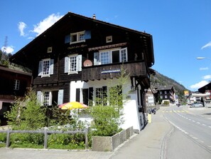 Un edificio in stile chalet tradizionale con un'insegna che recita 'Chalet des Alpes' e un'insegna per 'gotthard backpacker'.