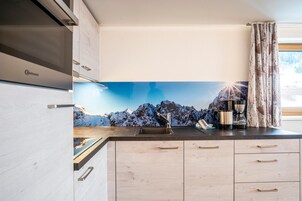 A modern kitchen with a built-in stove, a sink, and a coffee maker.