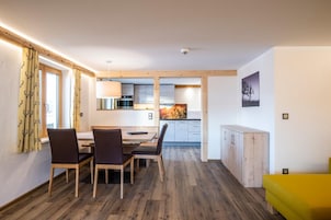 Una cocina moderna con armarios de madera y un comedor con mesa y sillas.