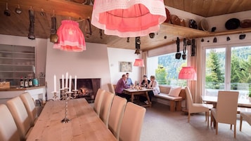 Un comedor con una larga mesa de madera, sillas y una chimenea.