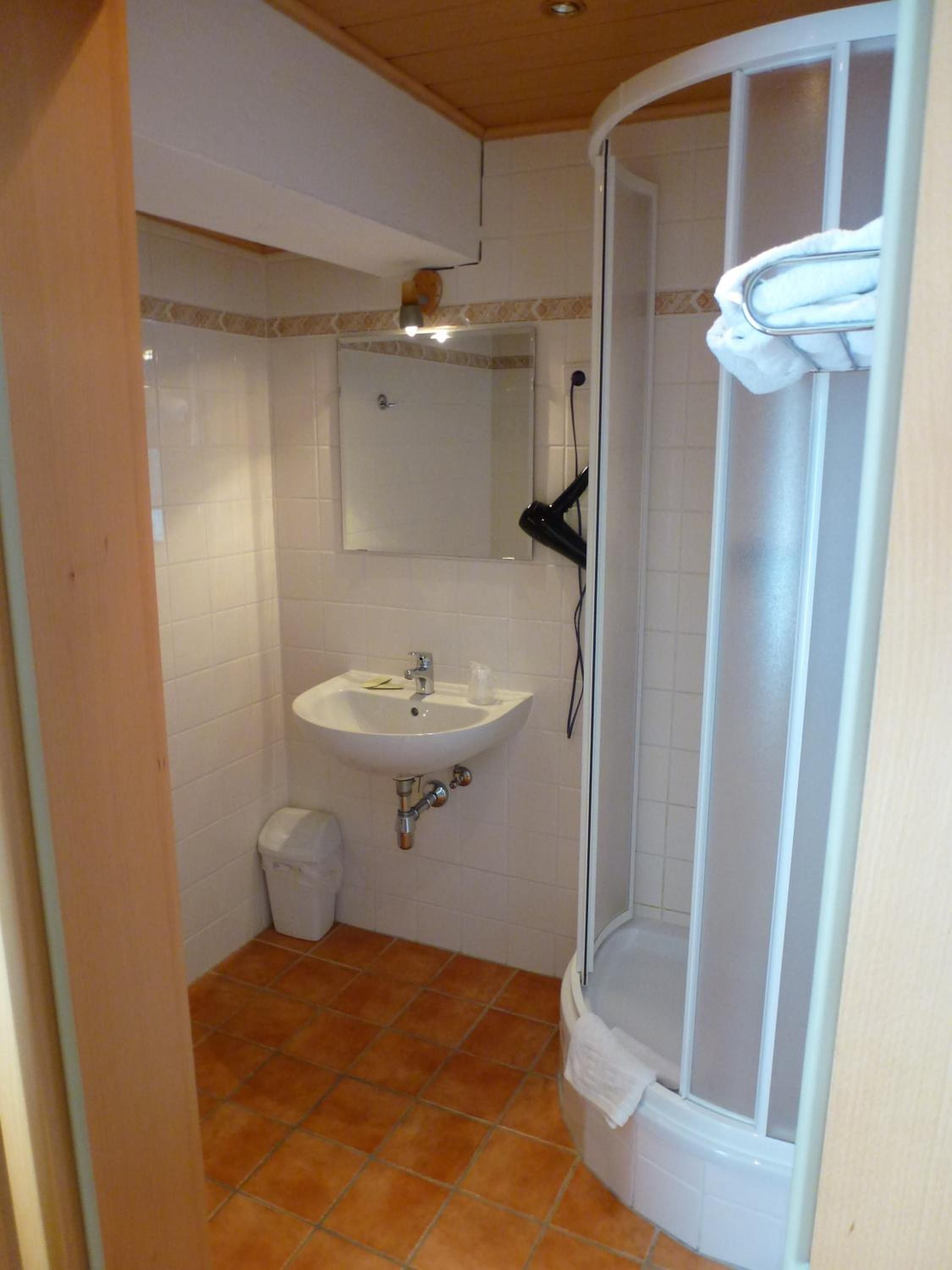 Un baño con lavamanos, espejo y ducha.