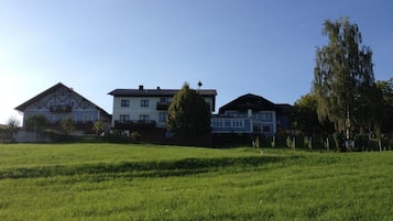 Ein Wohngebiet mit mehreren Häusern, einer großen Rasenfläche und blauem Himmel.