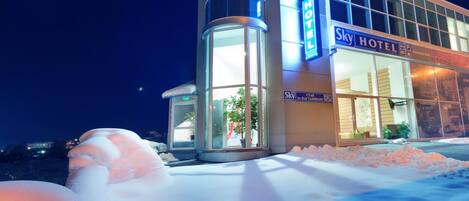 A hotel with a modern design, featuring large windows and a prominent 'Sky Hotel' sign.