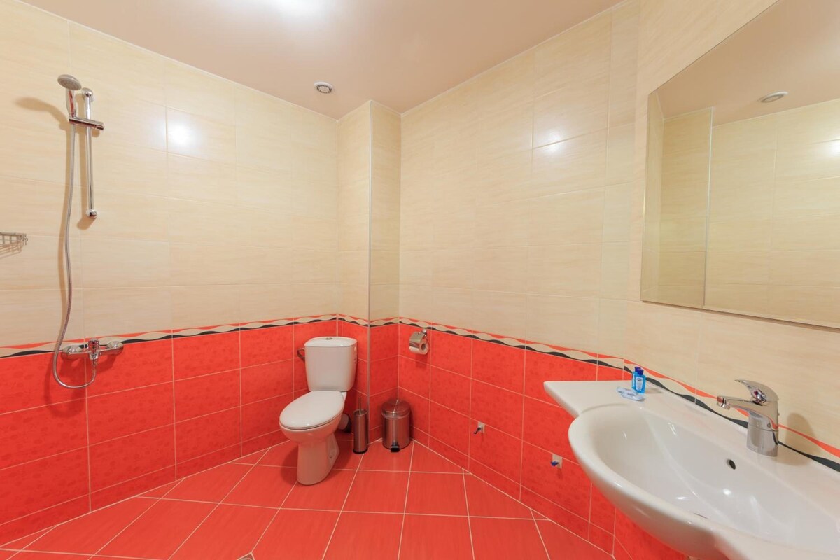 A bathroom with a toilet, bidet, and sink.
