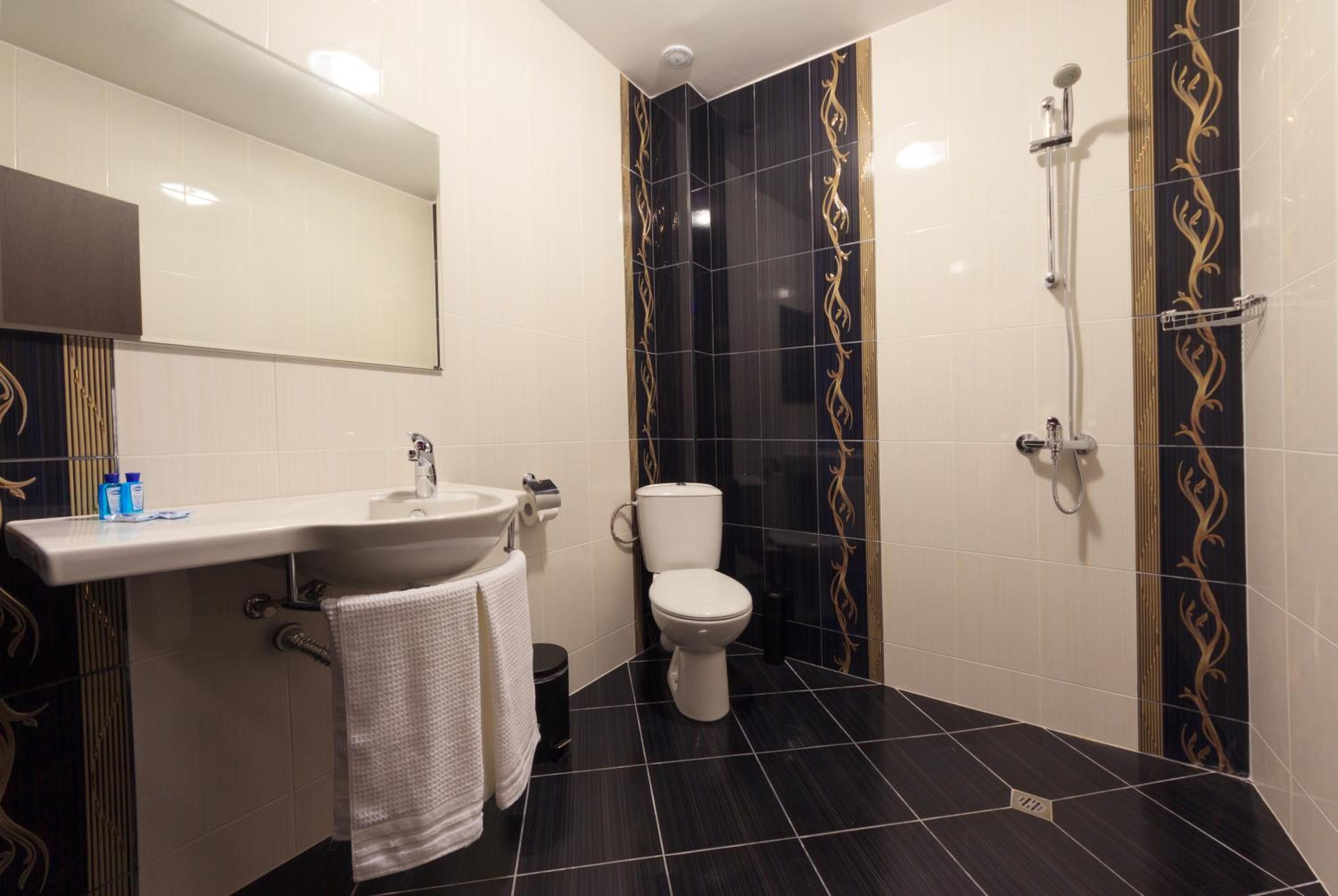 A bathroom with a sink, toilet, and shower.