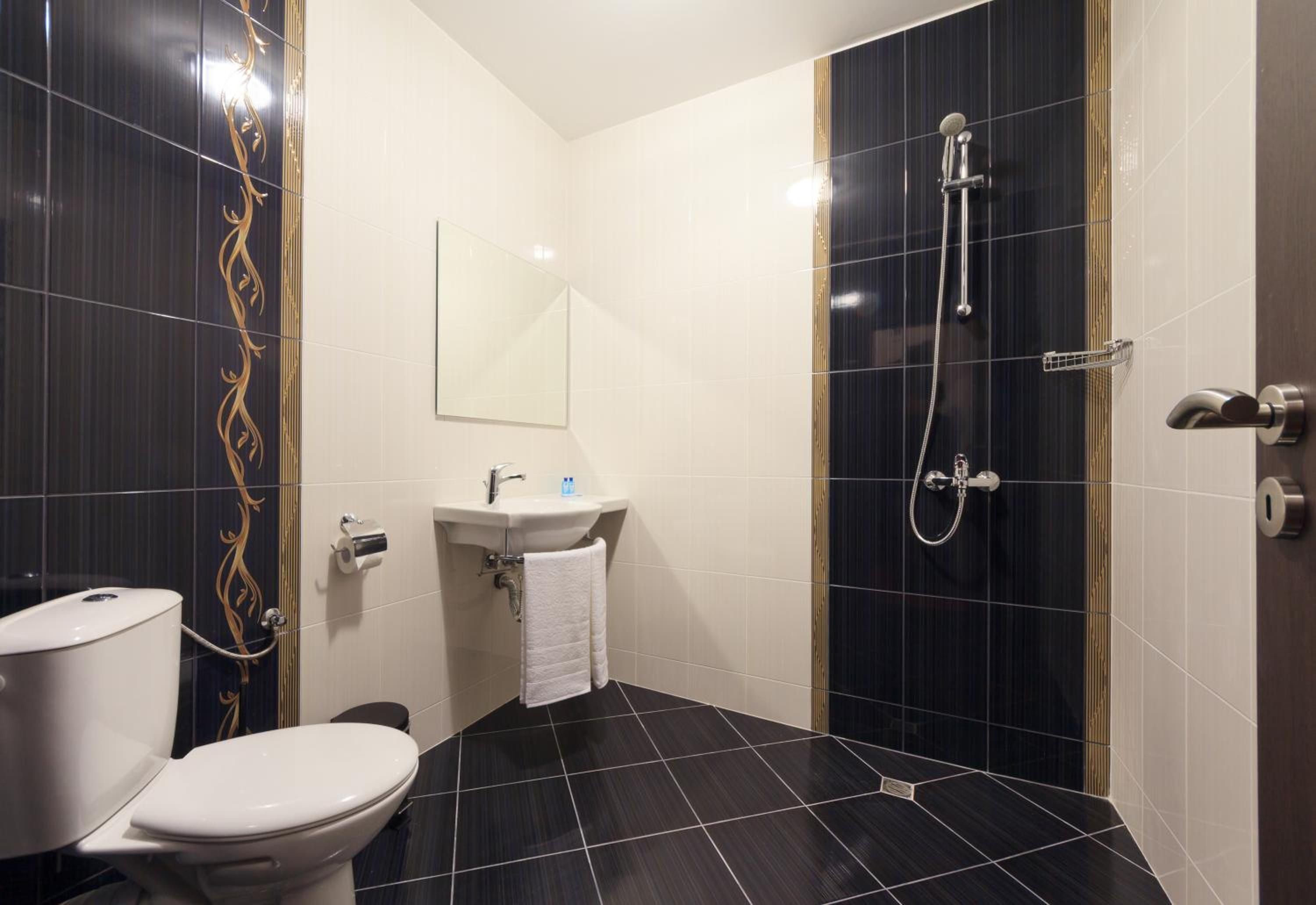 Un baño con inodoro, lavabo y ducha.