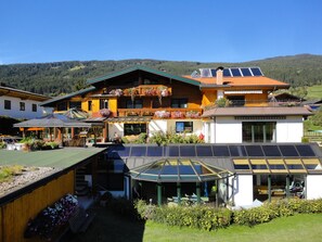 A large, multi-story building with a balcony, solar panels, and a covered outdoor area. - Wellnesshaus Reichelt (Radstadt)