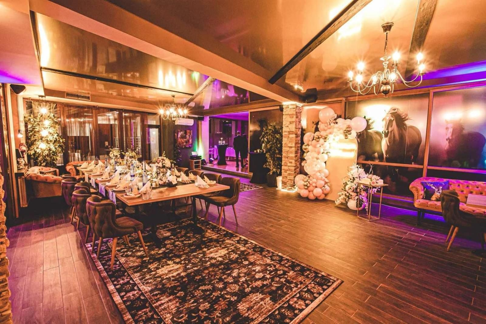 A spacious dining area with a long table set for a meal, surrounded by comfortable seating.