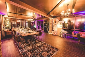 A spacious dining area with a long table set for a meal, surrounded by comfortable seating.