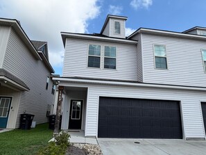 A two-story residential building with a garage, a front door, and a small front yard. - Tiger Country Retreat in Baton Rouge - CB1008 (Baton Rouge)