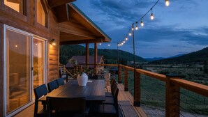 A wooden deck with a table and chairs, overlooking a mountainous landscape. - Epic Views, Sauna, Dog Lovers 5BR, 25 min to Breck (Breckenridge)