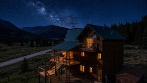 A log cabin with a balcony and a staircase leading to the upper level, surrounded by a mountainous landscape. - Epic Views, Sauna, Dog Lovers 5BR, 25 min to Breck (Breckenridge)