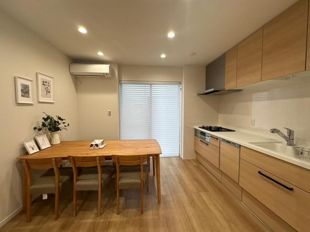 Una cocina moderna con armarios de madera, encimera blanca y estufa empotrada.