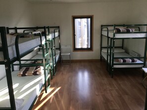 Un dormitorio con literas, una ventana y un radiador.