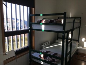 Habitación con literas y ventana con vista al paisaje.