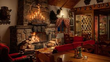 Un intérieur chaleureux avec une cheminée en pierre, des meubles en bois et un meuble à vin.