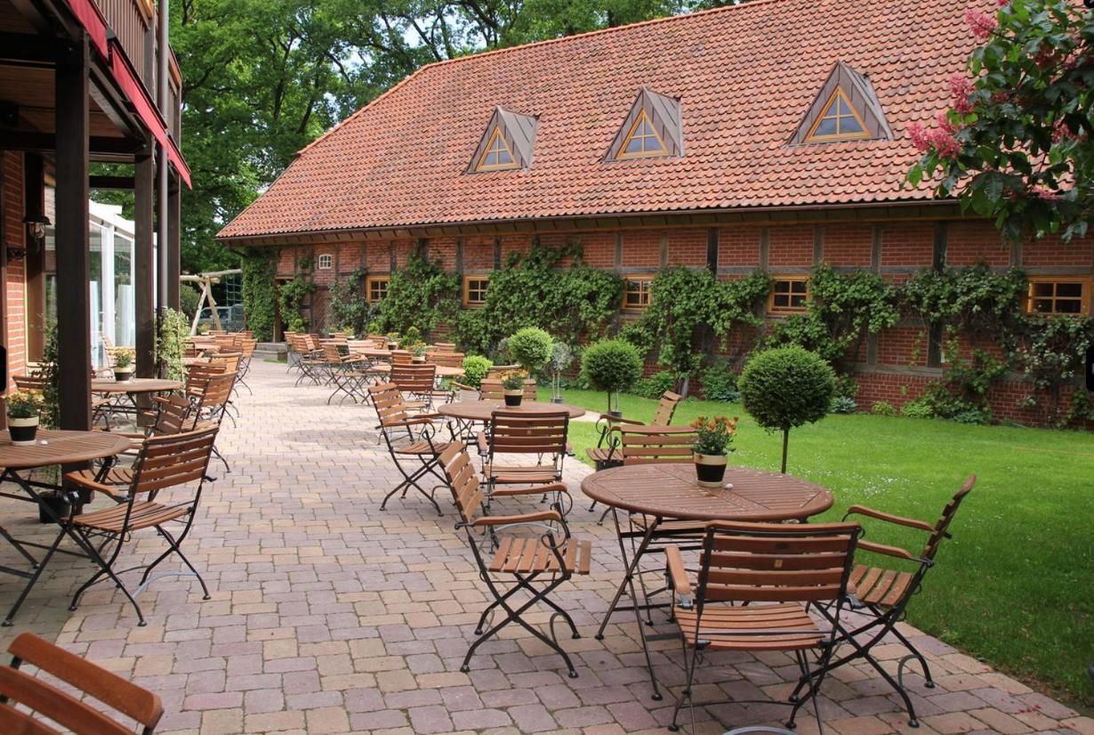 Un patio con mesas al aire libre y un edificio de techo con tejas.
