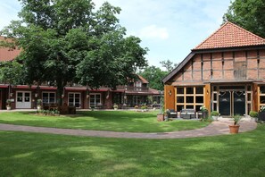 A building with a brick facade, large windows, and a well-maintained lawn. - Büchtmannshof (Wietze)