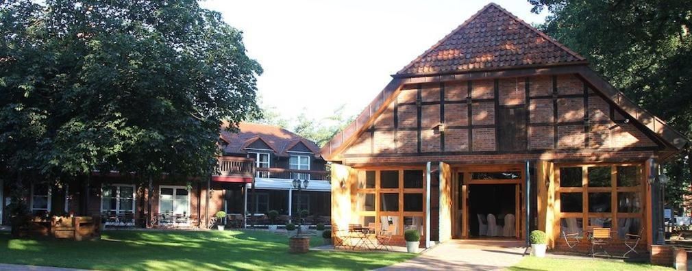A traditional wooden building with a sloped roof, large windows, and a covered porch area.