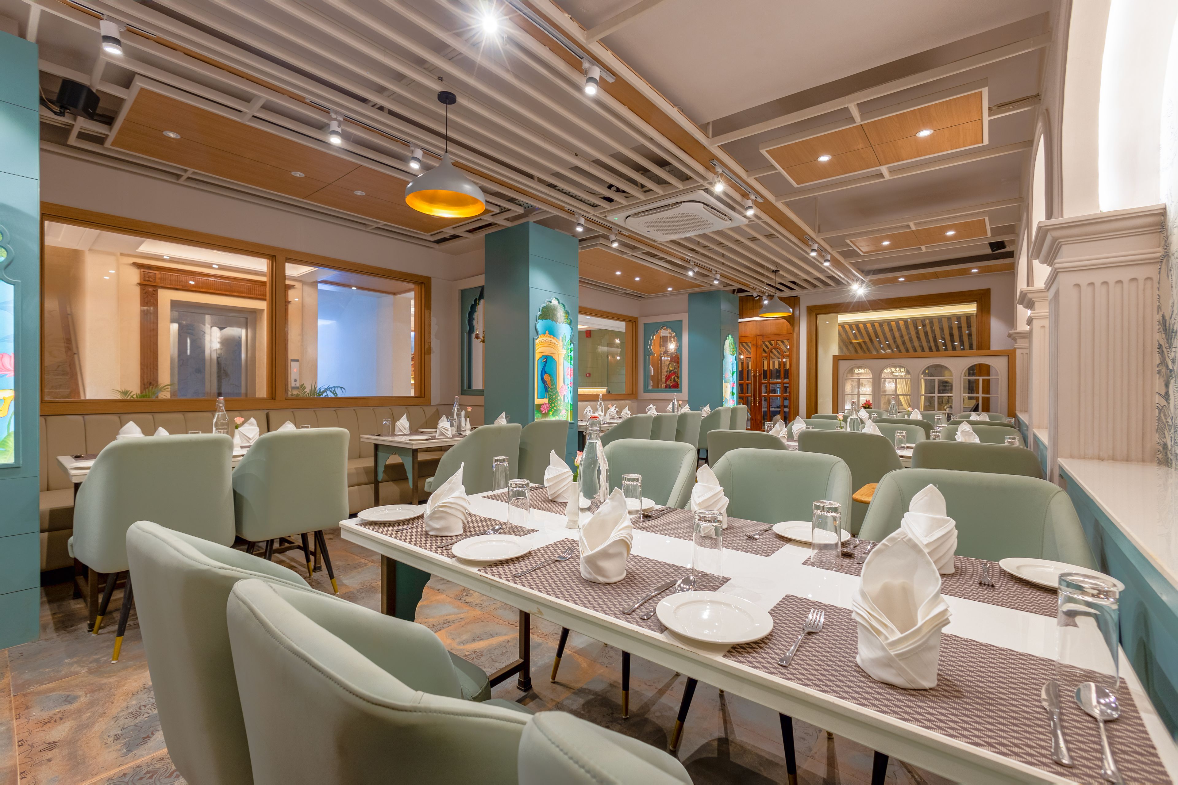 A restaurant with multiple dining tables, chairs, and a variety of table settings.