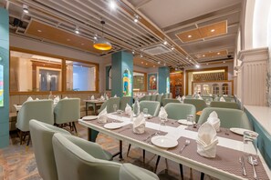 Un restaurante con varias mesas, sillas y diferentes tipos de mantelería.