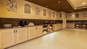 Uma cozinha ampla com armários de madeira, bancadas de mármore e diversos utensílios de cozinha.