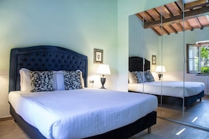 Una camera da letto con un letto grande, un comodino, uno specchio e una finestra.