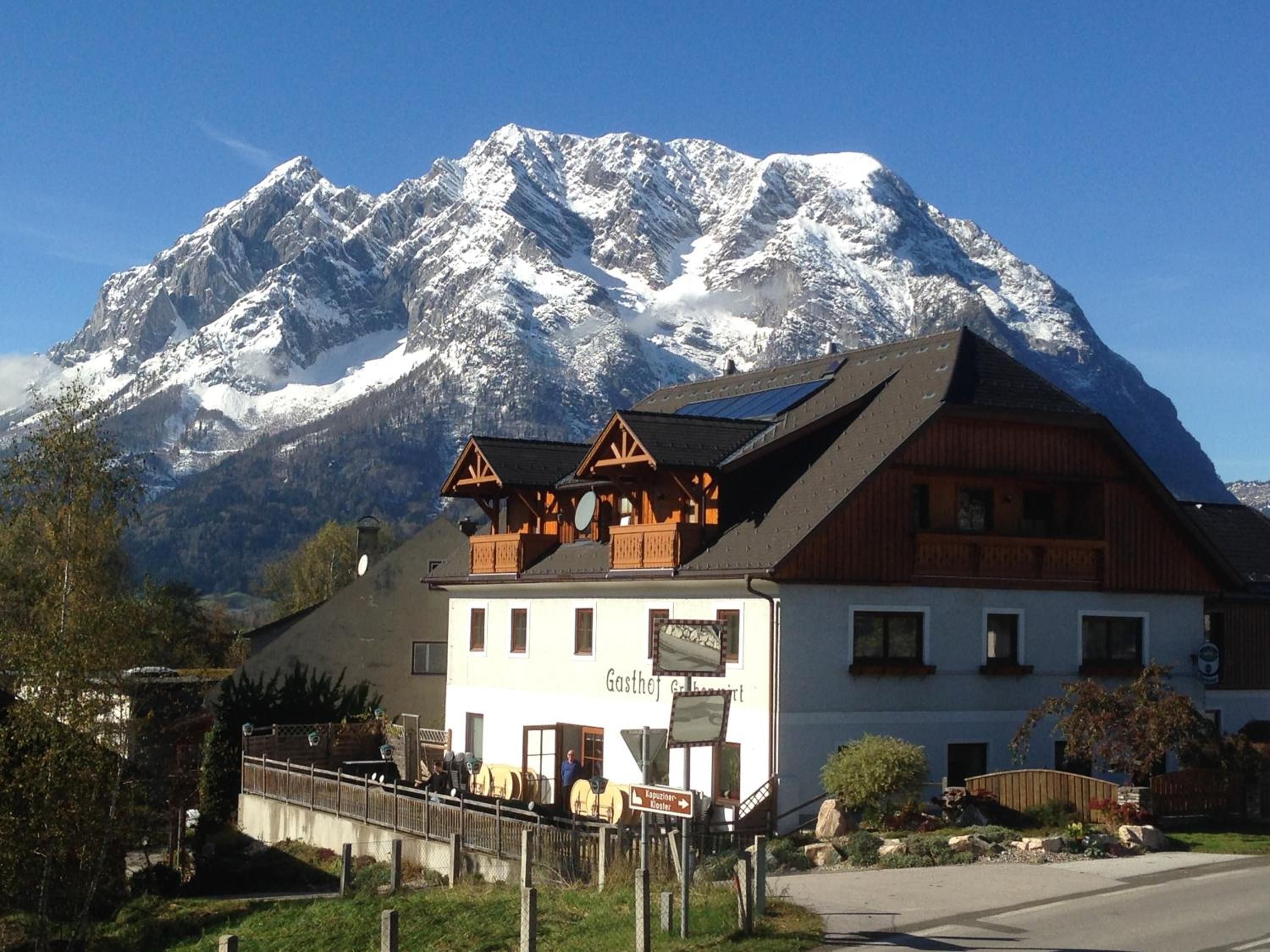 Eine Berglodge mit Holzfassade, einem Balkon und einem Schild, das ein Restaurant anzeigt.