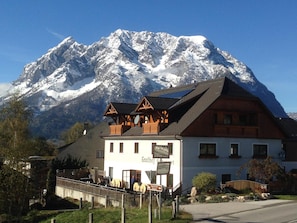 A mountain lodge with a wooden facade, a balcony, and a sign indicating a restaurant. - Gasthof Grabenwirt (Irdning-Donnersbachtal)