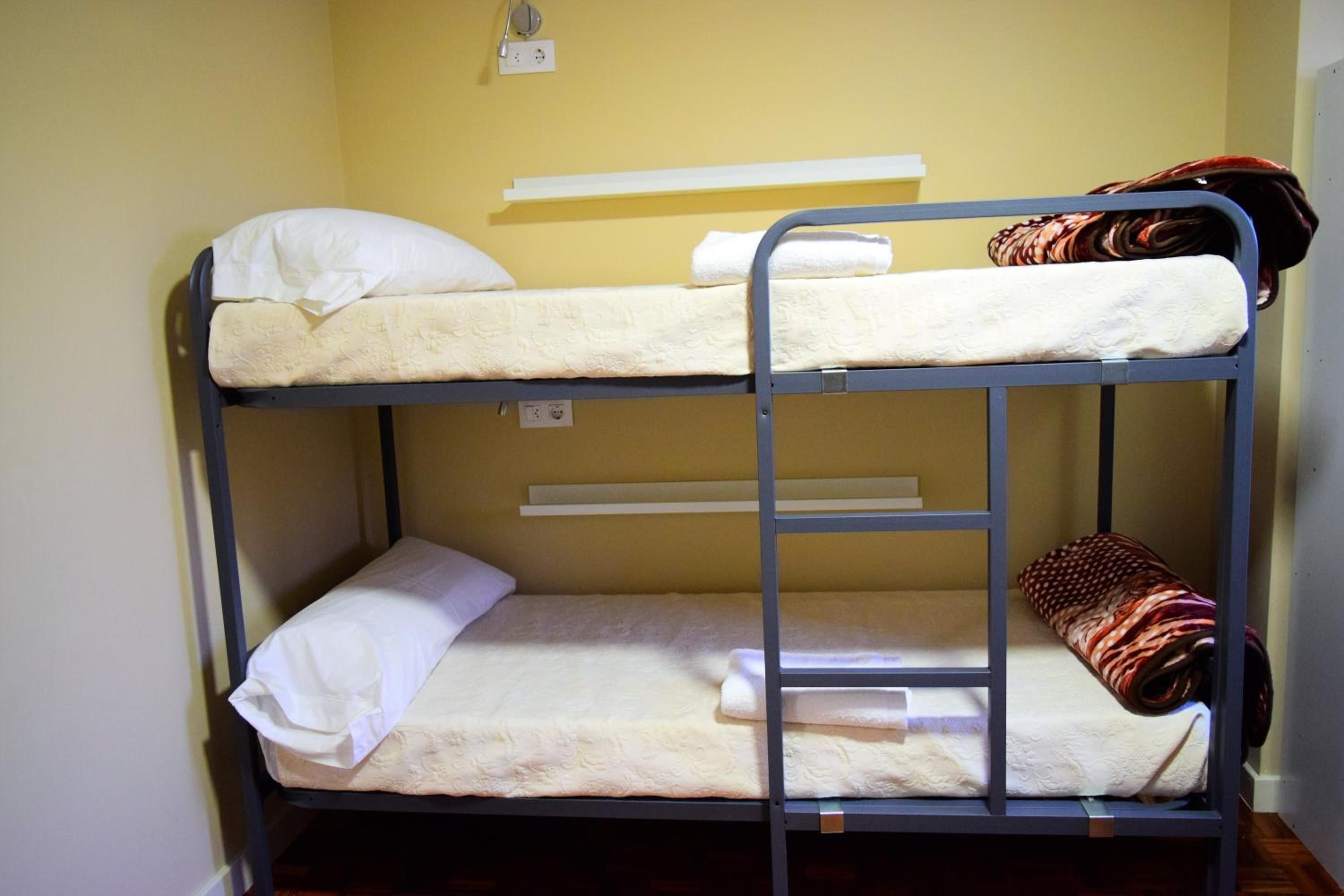 Een stapelbed met twee verhoogingen, elk met een kussen en een dekbed.