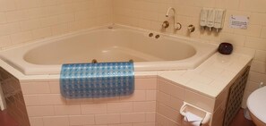 A bathroom with a bathtub, a towel rack, and a toilet. - Golfview Lodge (Bowral)