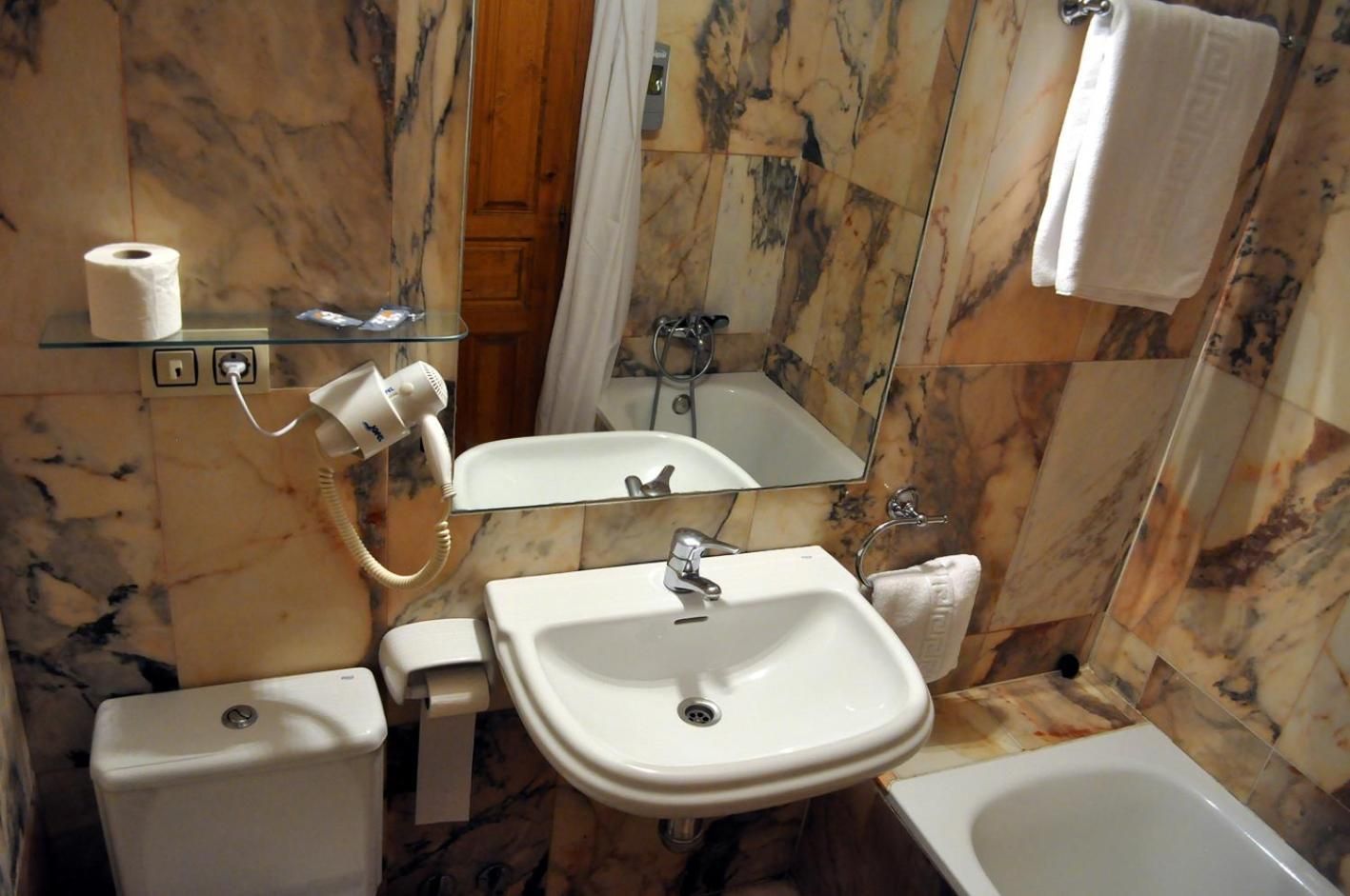 Un baño con inodoro, lavamanos y bañera.