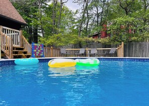 A swimming pool with inflatable rings and a wooden deck. - Horizon Chalet Private Pool Hot Tub Pet Friendly (Long Pond)