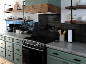A kitchen with a stove, oven, and various kitchen items on shelves. - Horizon Chalet Private Pool Hot Tub Pet Friendly (Long Pond)