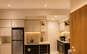 A modern kitchen with built-in appliances, a marble backsplash, and wooden cabinetry. - Zenity Luxury Central HCM by BEARHOUSE (phuong cau ong lanh)