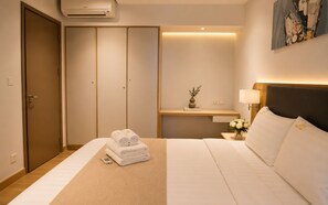 A hotel room with a bed, a bedside table with a lamp, a wall-mounted air conditioner, and a wardrobe. - Zenity Luxury Central HCM by BEARHOUSE (phuong cau ong lanh)