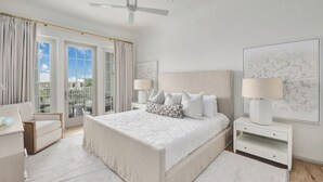 A spacious bedroom with a large bed, a ceiling fan, and a view of the outdoors through large windows. - A Welcoming Space for Your Next Vacation! Onsite Pool, Free Parking! (Walton County)